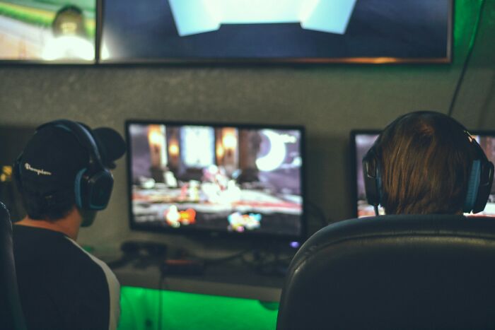 Two gamers wearing headsets sitting in front of computer screens, representing growing trends in the tech economy
