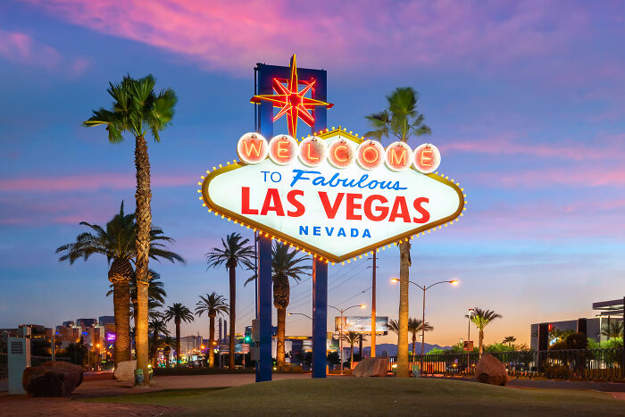 The iconic Welcome to Fabulous Las Vegas sign glowing at dusk, representing experiences wealthy people buy.
