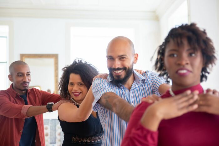 A group of diverse couples dancing, enjoying a wedding party. A wild turn of unexpected fun and laughter.