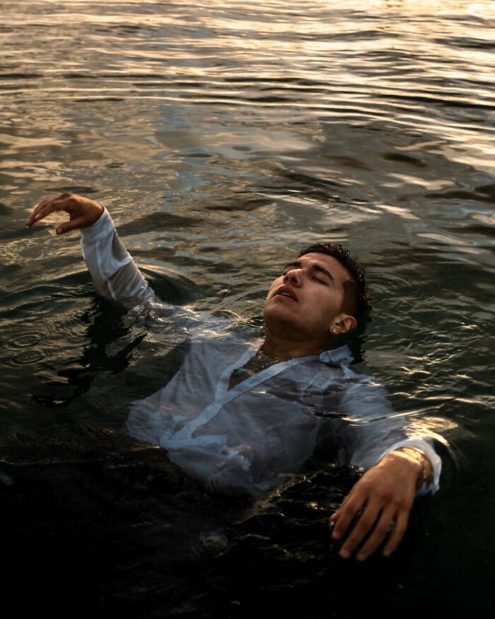 A man floating in water, fully clothed, after a wild turn at a wedding event.