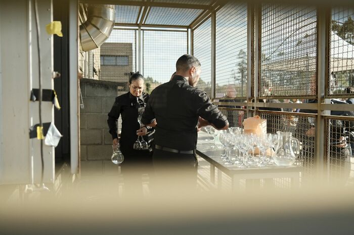 Catering staff preparing glasses for a wedding reception, a wild turn for the event.