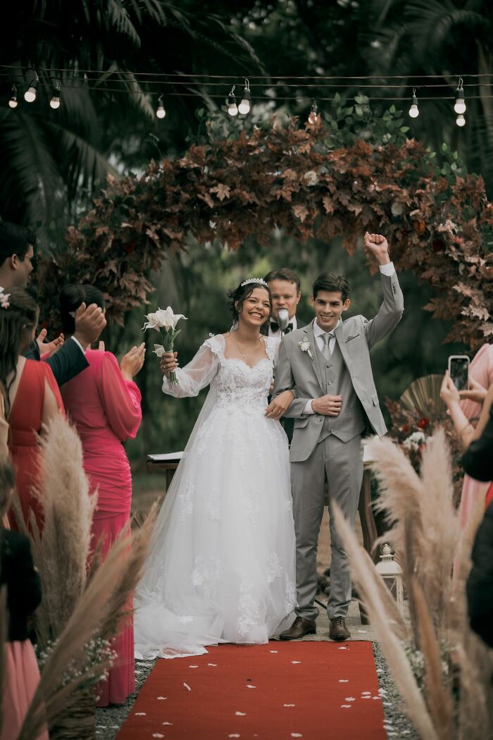 A happy newlywed couple in wedding attire walks down an aisle, celebrating their wedding day, a wild turn.