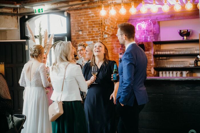 Guests laughing and socializing at a wedding reception, a wild turn of events.