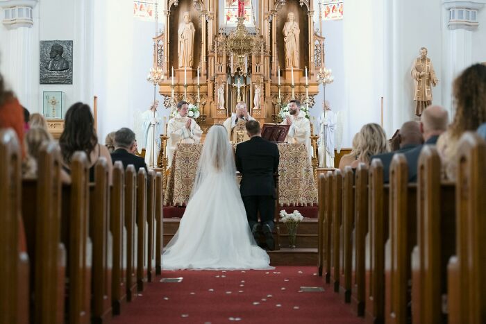 A kneeling bride and groom at a church wedding ceremony, a wild turn in their special day.
