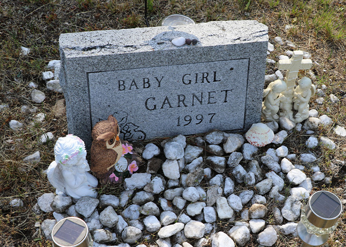 A grave for 'Baby Girl Garnet' from 1997, connected to an ancestry DNA test and homicide investigation.