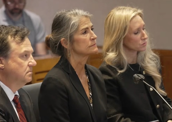 A woman with grey hair sits in a courtroom, a serious expression on her face. Her Ancestry DNA Test led to a grandma arrested for homicide.