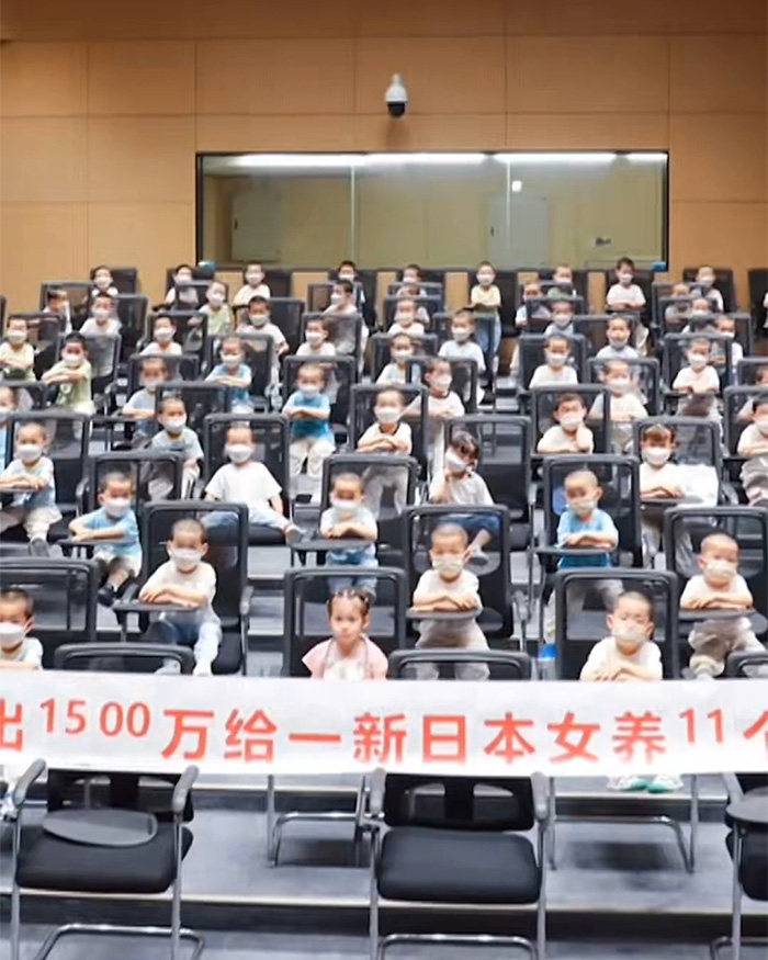 A room full of young children, all wearing masks, in a shocking surrogate baby reveal.
