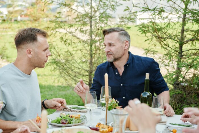 Two men talking at a table, representing a guy who wont marry his girlfriend and relationship struggles.