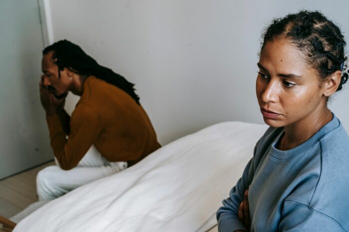 A woman looking hurt as her boyfriend avoids saying I love you, showing relationship struggles.