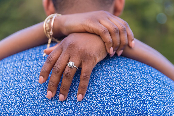 A woman wearing an engagement ring, her arm around a man. This image represents women who turned down marriage proposals.