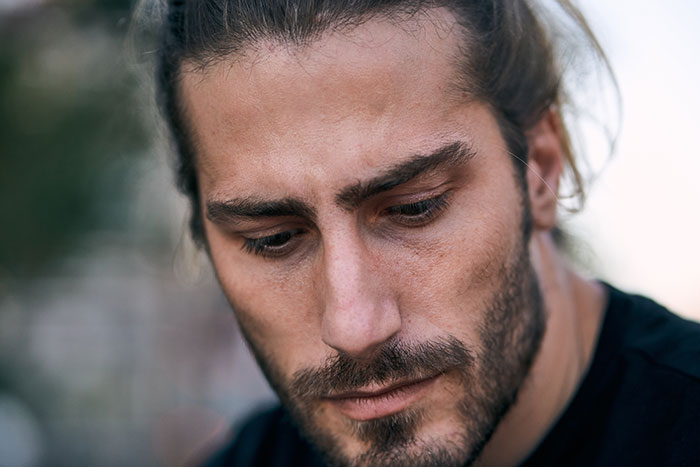 Man with a beard, looking down, thinking about women who turned down marriage proposals and their choices.