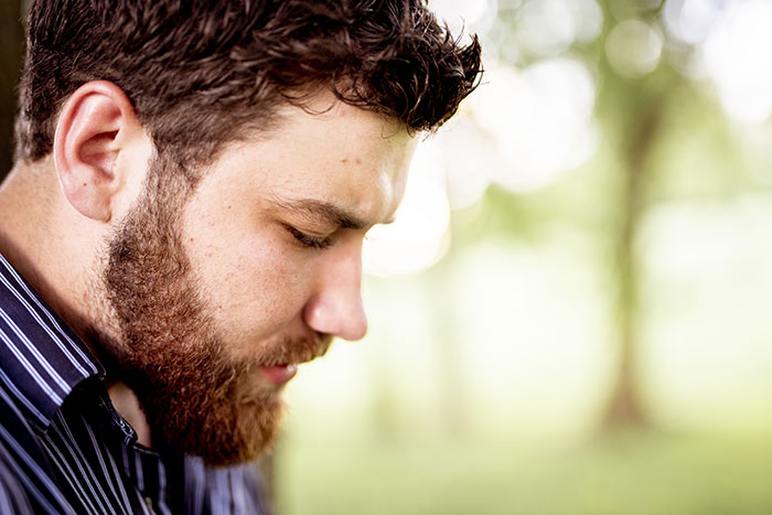 A man looks down sadly, possibly after his marriage proposal was turned down.