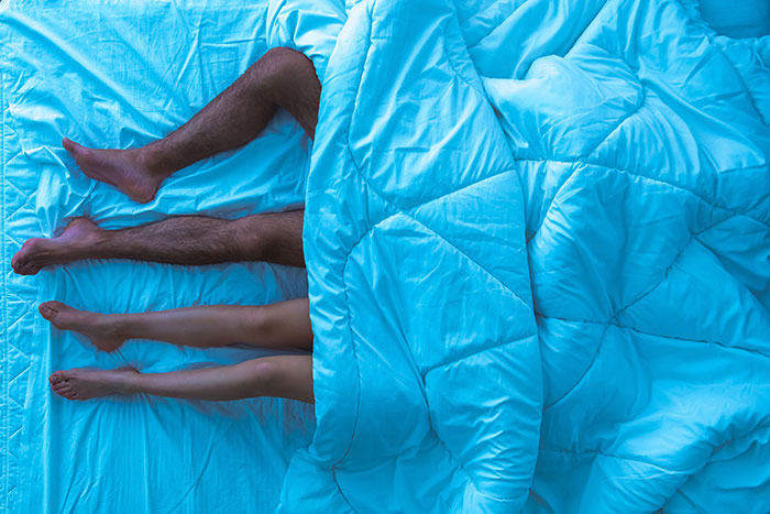 Three people in bed, representing different choices in marriage proposals.