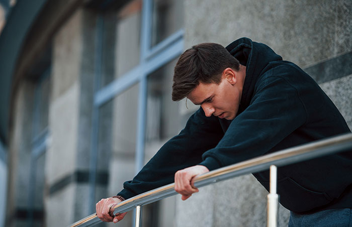 A man looking down, sad after his marriage proposal was turned down.