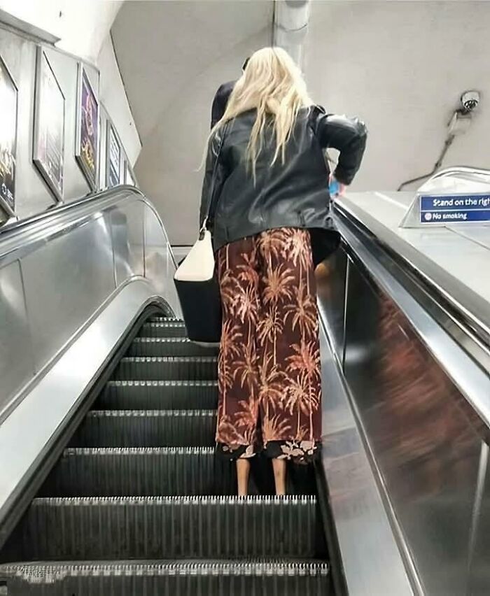 A woman on an escalator with legs that look incredibly thin, making you look twice.