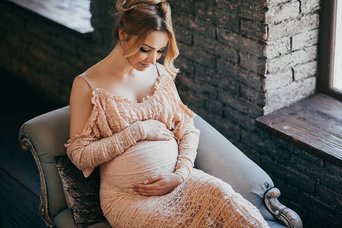 Pregnant woman sitting in an armchair, reflecting on family and marriage regrets