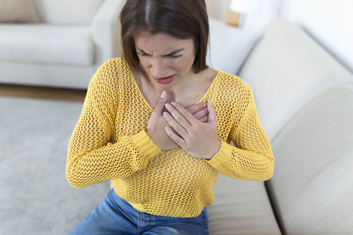 A woman experiencing chest pain, one of the health symptoms that terrify doctors.