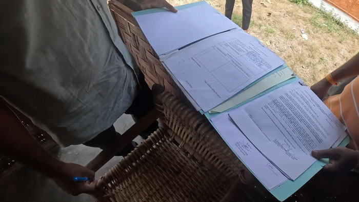 Two people looking at documents on a wicker table after a YouTuber visited one of the most dangerous islands.