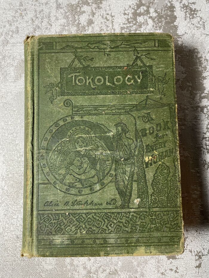 A worn green cover of Tokology, a book on maternity and health from medical history.