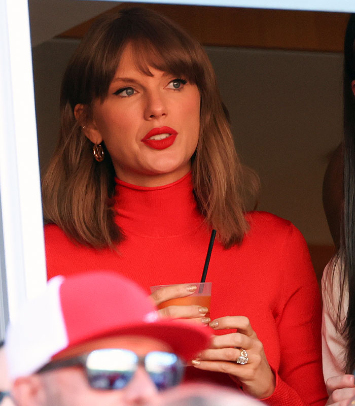 Taylor Swift holding a drink in a red top at the Chiefs game Taylor Swift holding a drink in a red top at the Chiefs game