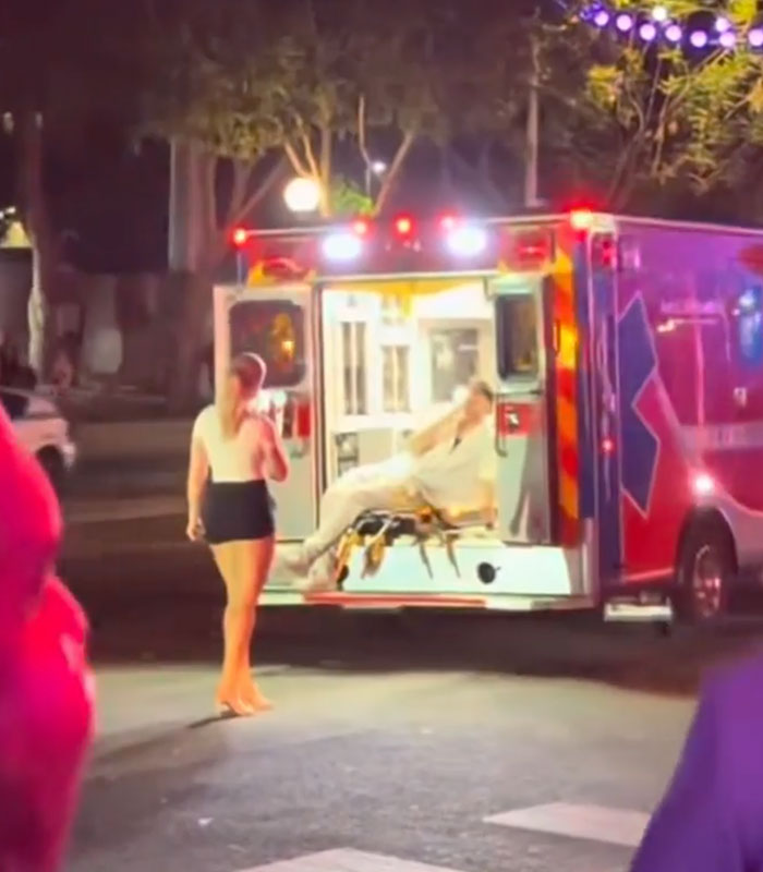 An influencer posing in front of an ambulance at night An influencer posing in front of an ambulance at night