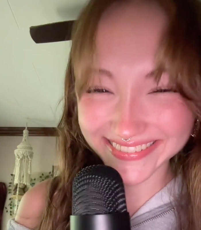 A server smiling while holding a microphone speaking about unhinged things customers have said. A server smiling while holding a microphone speaking about unhinged things customers have said.