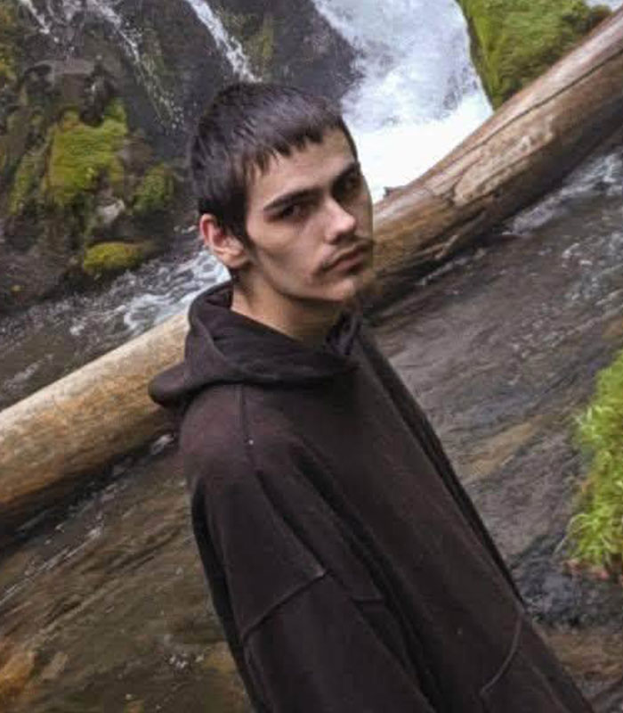 Teen involved in the Oregon elementary school tragedy wearing a dark hoodie near a waterfall.