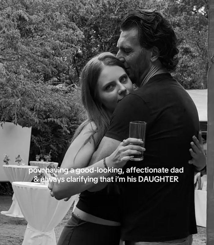 A black-and-white photo of a woman showing her close bond with her dad in an embrace outdoors.