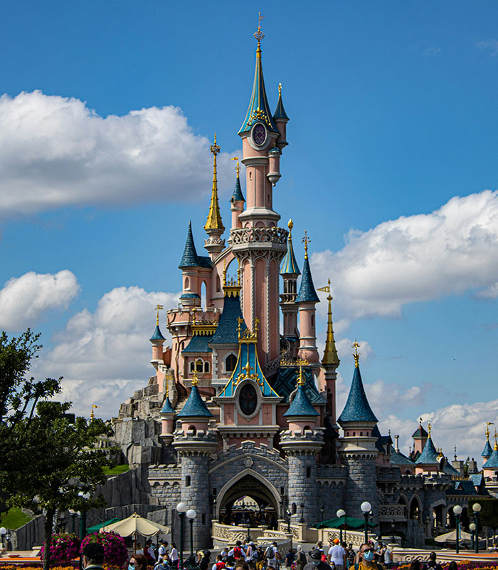 Grand Disney World castle towering under a clear blue sky, central to the family park experience.