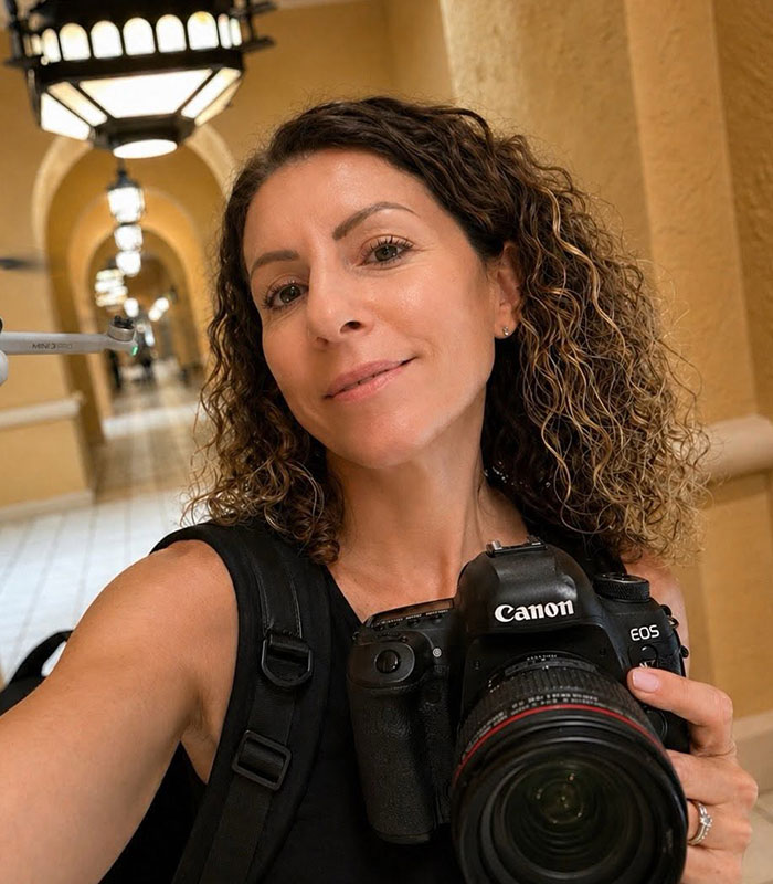 A mom who took a Vegas trip taking a selfie while holding a Canon DSLR camera.
