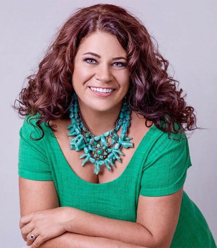 Headshot of bestselling author Tricia O'Malley wearing a green top and turquoise necklace