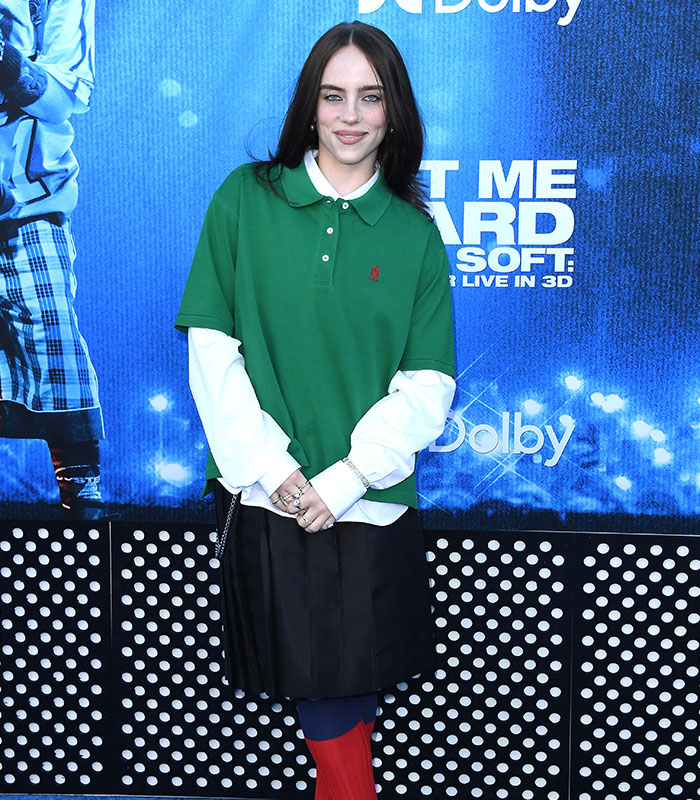 Billie Eilish smiling on the red carpet, showcasing her slimmed down figure in green polo shirt Billie Eilish smiling on the red carpet, showcasing her slimmed down figure in green polo shirt