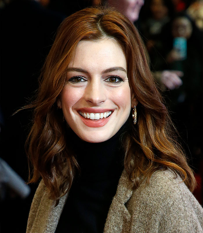 Smiling actress with wavy hair in coat and turtleneck at event Smiling actress with wavy hair in coat and turtleneck at event