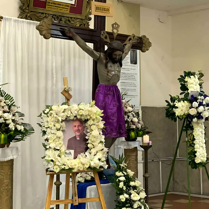 Crucifix and photo memorial of priest surrounded by flowers in church Crucifix and photo memorial of priest surrounded by flowers in church