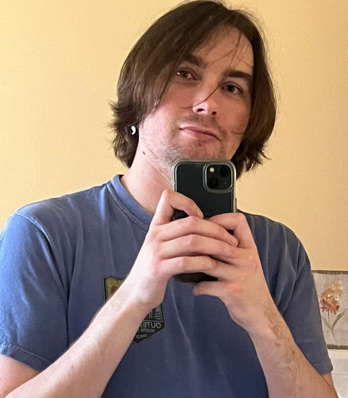 Bryan Kohberger's friend taking a mirror selfie wearing a blue t-shirt and holding a smartphone