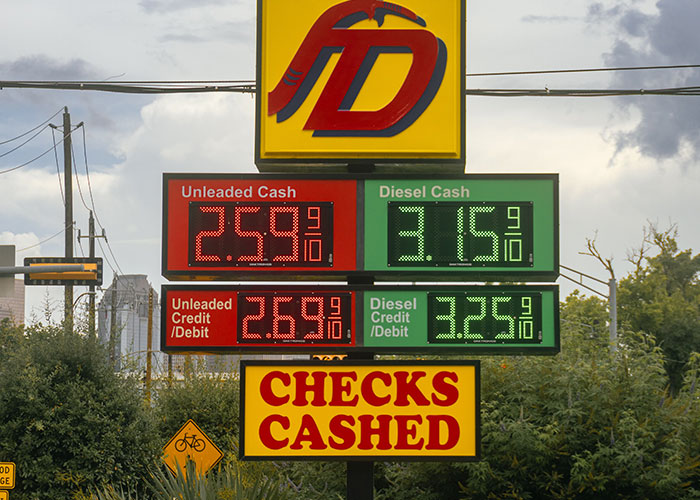 A gas station price sign displaying unleaded and diesel rates, contrasting expenses with a permanent cruise lifestyle.