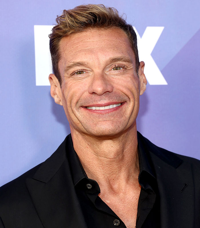 A close-up headshot of a smiling Ryan Seacrest highlighting his physical appearance. A close-up headshot of a smiling Ryan Seacrest highlighting his physical appearance.