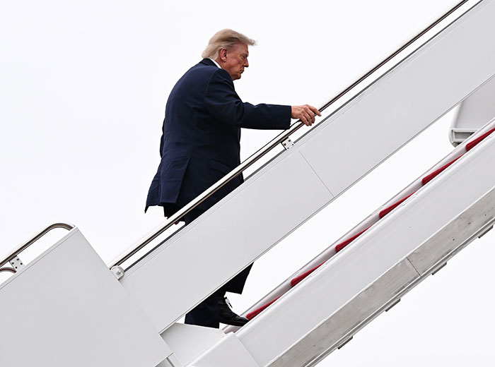 Donald Trump climbs the stairs to Air Force One. Donald Trump climbs the stairs to Air Force One.