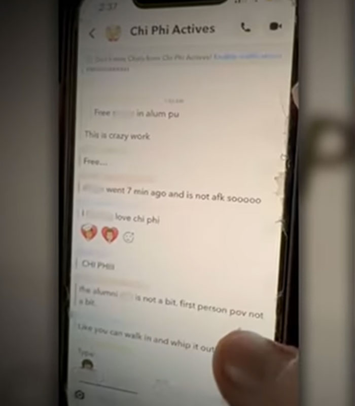 A hand holding a smartphone showing a Snapchat message from Chi Phi Actives chat group linked to Cornell 7. A hand holding a smartphone showing a Snapchat message from Chi Phi Actives chat group linked to Cornell 7.