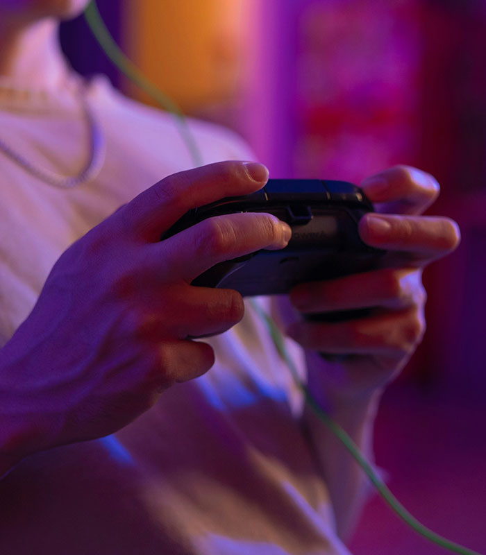 Close-up of hands holding a gaming controller, related to a husband shamed online for a video game contract. Close-up of hands holding a gaming controller, related to a husband shamed online for a video game contract.