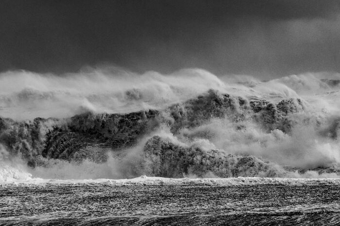 Dramatic dramatic wave breaking near a black sand shore in Iceland in black and white