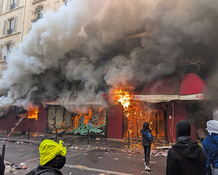 A storefront engulfed in flames and thick smoke during the France riots