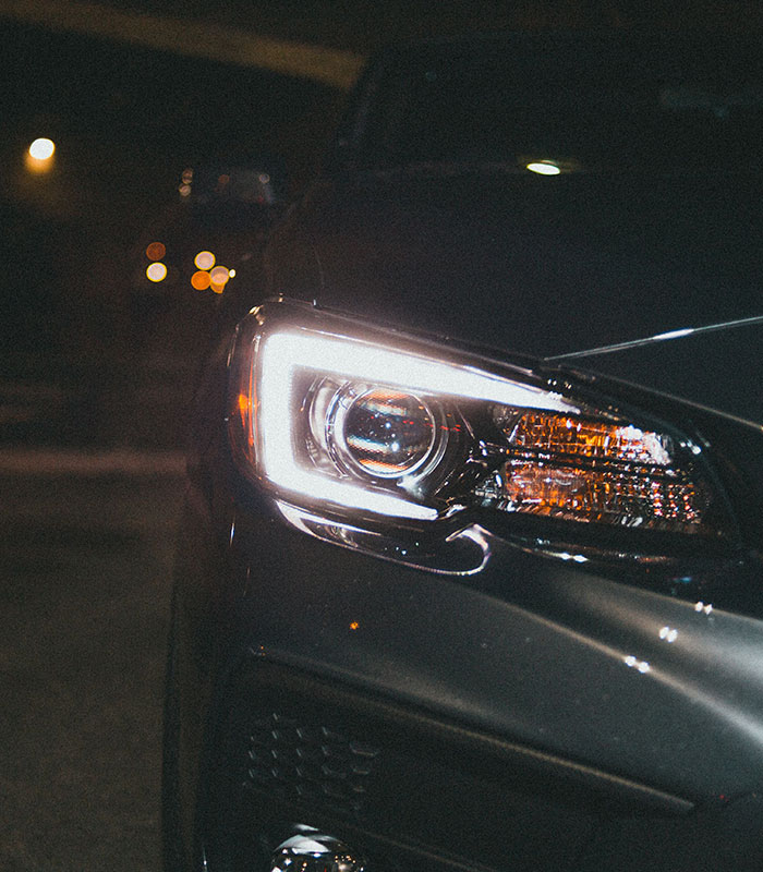 Close-up of glowing car headlight at night showing contrast to nighttime flying. Close-up of glowing car headlight at night showing contrast to nighttime flying.