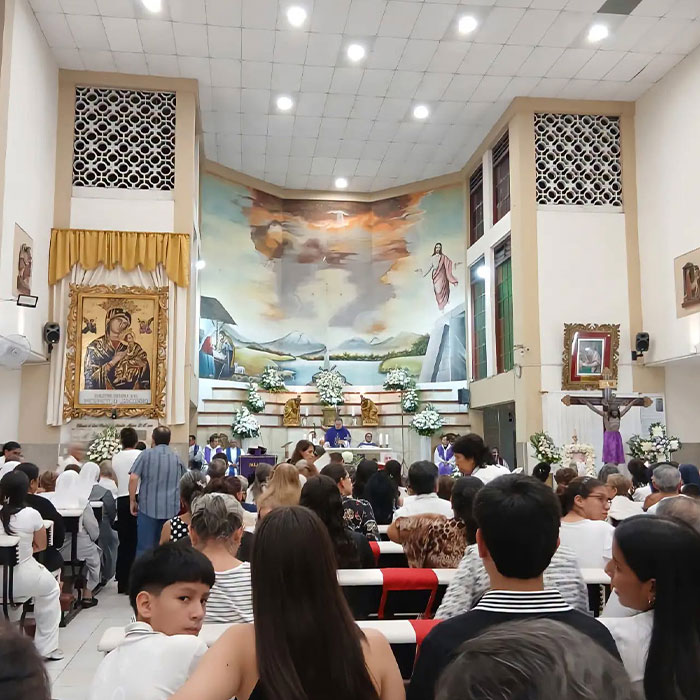 Church interior filled with congregation during mass with crucifix Church interior filled with congregation during mass with crucifix