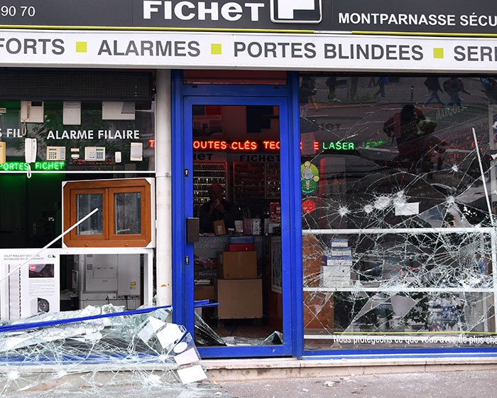 A damaged shop front with shattered glass after the France riots