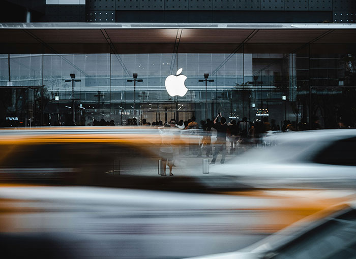 A busy street scene outside an illuminated Apple store amid a crackdown on looters in France.