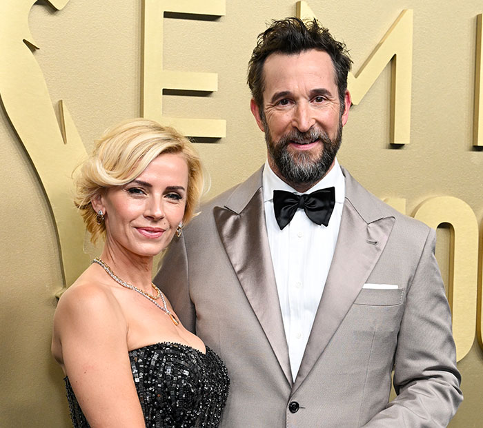 Noah Wyle posing on the red carpet next to a blonde woman in a formal dress