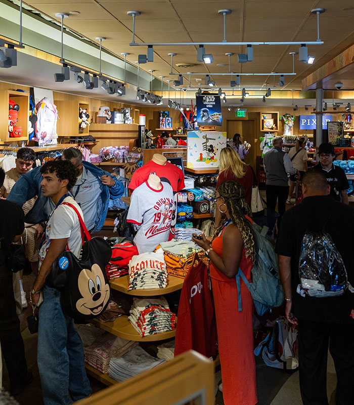 Disney World guests browsing merchandise inside a crowded park gift shop. Disney World guests browsing merchandise inside a crowded park gift shop.