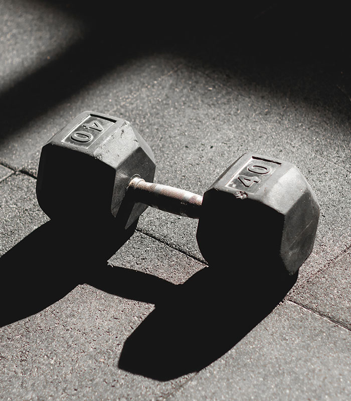 A heavy dumbbell on a gym floor representing strength, relating to the mom who left kids home alone story