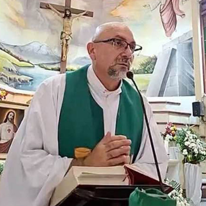 Priest delivering sermon in church with crucifix and mural Priest delivering sermon in church with crucifix and mural
